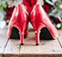 Pair of red patent leather heels on wooden surface