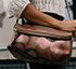 Woman holding brown and pink floral leather bag